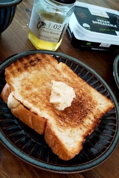 焼き網で焼いた食パンにヴィーガンバターをのせている