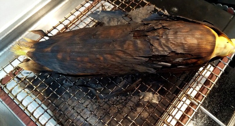 皮が真っ黒になって焼きあがったトウモロコシ