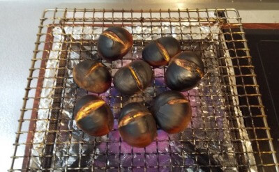 焼き網の上で焼かれ黒くなった和栗