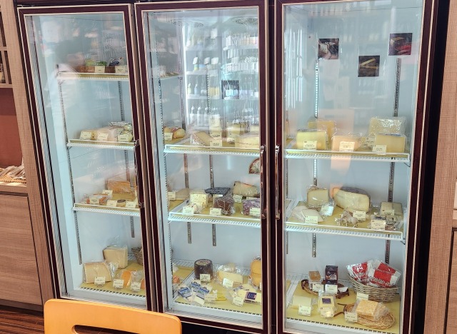 大きな冷蔵庫にはいった数種類のチーズ