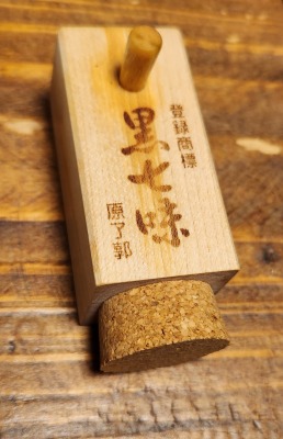 黒七味がはいった木の入れ物