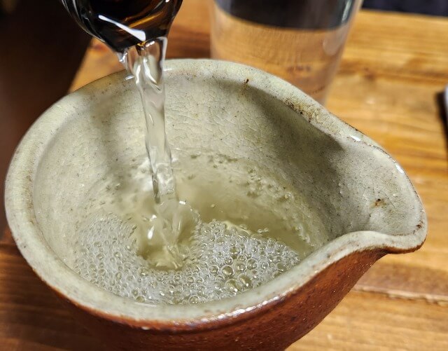 七本鎗を酒器に注いでいる